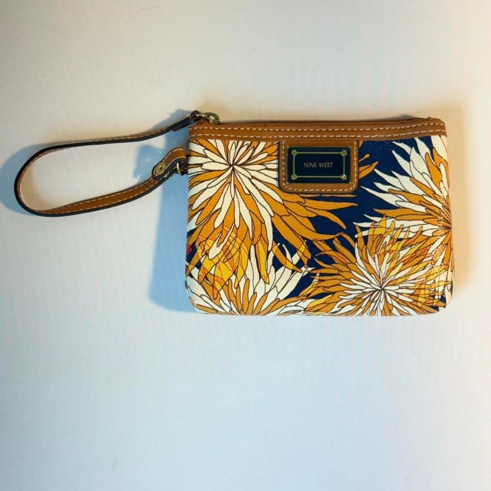 Faux tan leather and bright floral wristlet with a zipper closure